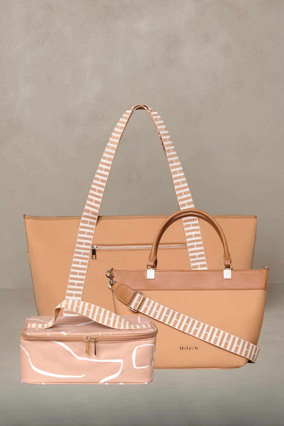 Set of three bags including a large tan tote, medium tote, and small pouch with striped handles on a gray background.