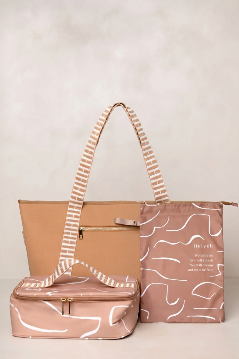 three bags, one tan carry all and two tan with white patterns, on a light background