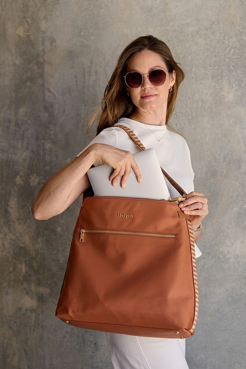 Woman holding a Tan Cognac nylon bag against a concrete background