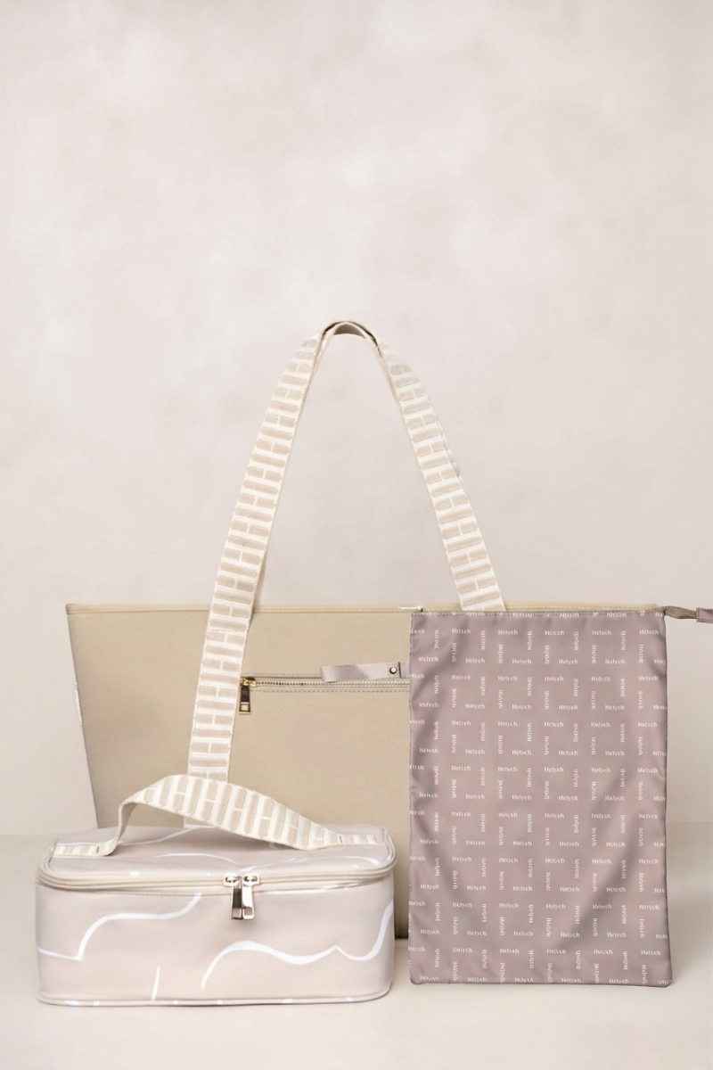 Set of bags including a taupe tote, lunch box, and patterned pouch on a light background